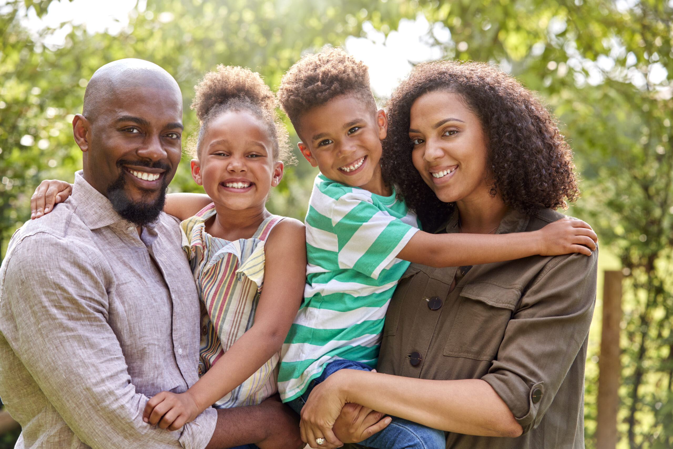 Portrait Of Smiling Family At Home Outdoors In Garden Together