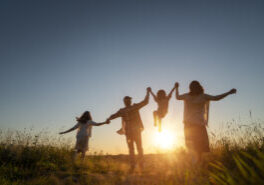 Happy family in the park. Father, mother and children are running, having fun and enjoying summer evening.