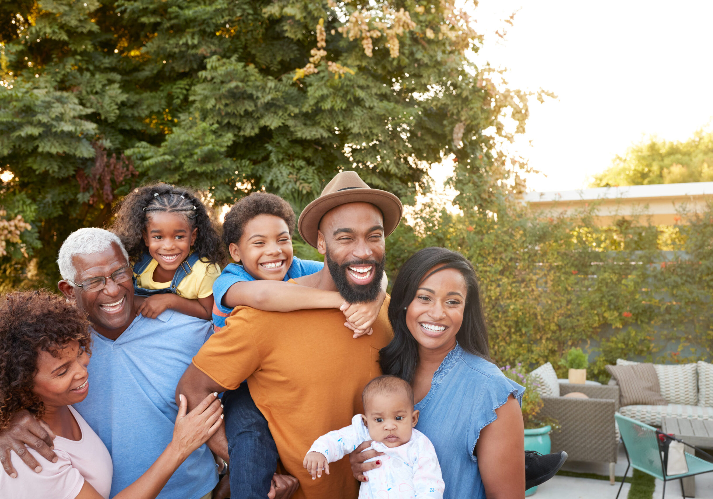 Portrait Of Multi-Generation African American Family Relaxing In Garden At Home Together